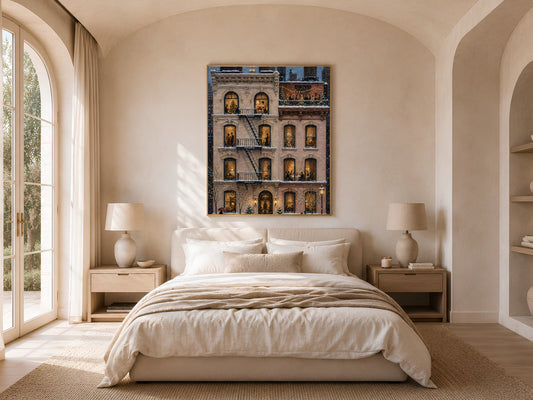 NYC Christmas painting framed above bed in sunlit bedroom with arched window