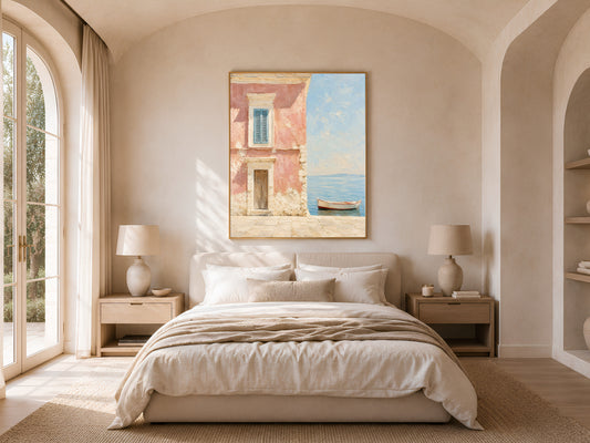 Coastal wall art print hanging above a neutral bed in a sunlit bedroom with arched French doors, Positano-inspired pink house and boat painting