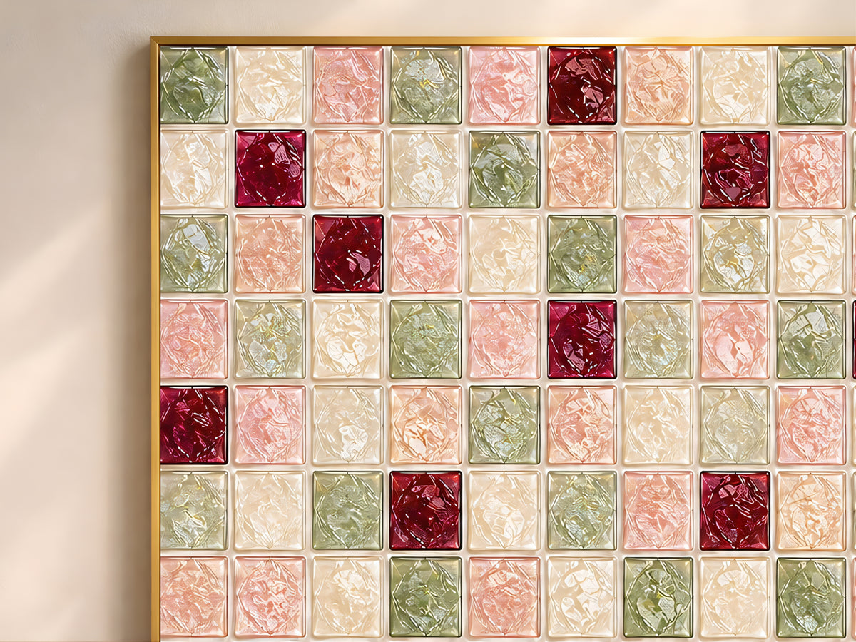 Close-up of geometric mosaic wall art in sage green, blush pink, cherry red, and cream glass-tile pattern