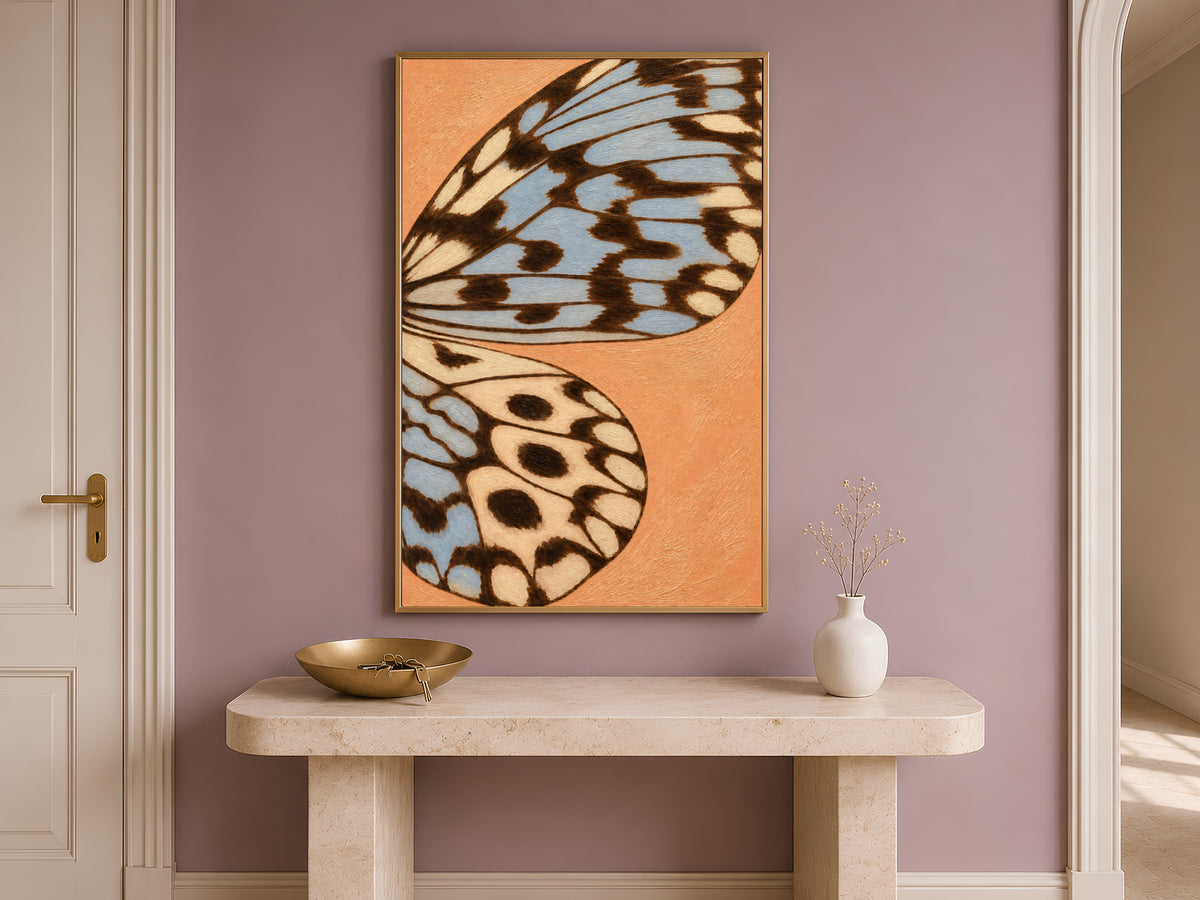 Terracotta and blue butterfly wing art framed on a mauve wall above a console table in an entryway