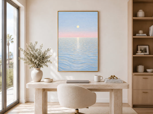 Pastel moon ocean wall art framed above home office desk with bookshelf and window