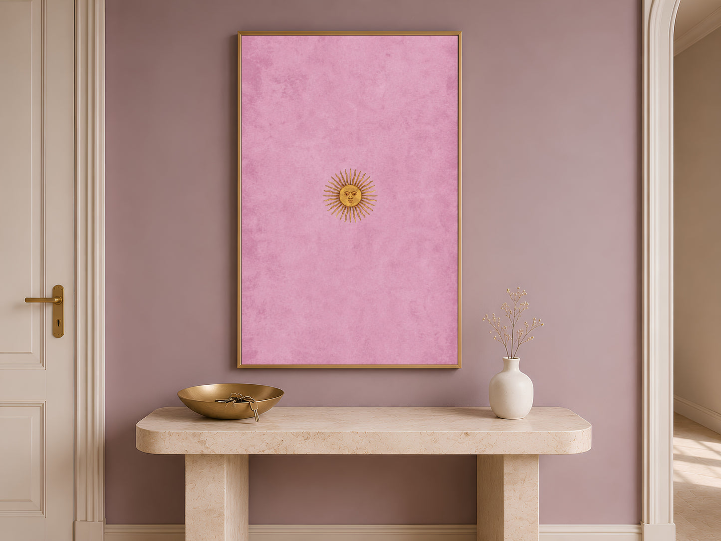 Vintage sun face wall art hung above an entryway console table, celestial gallery print in gold and pink