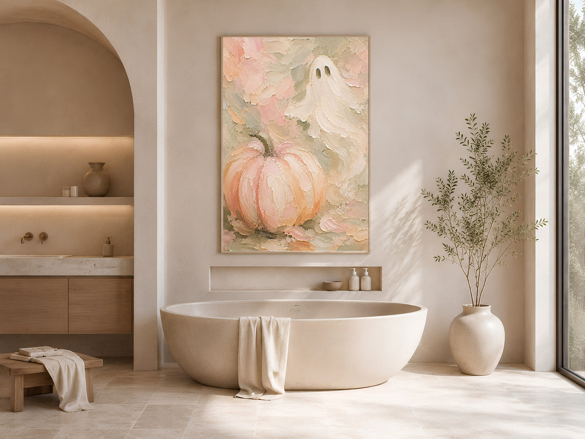 Pastel sage green pumpkin ghost art print framed above a freestanding tub in a neutral bathroom