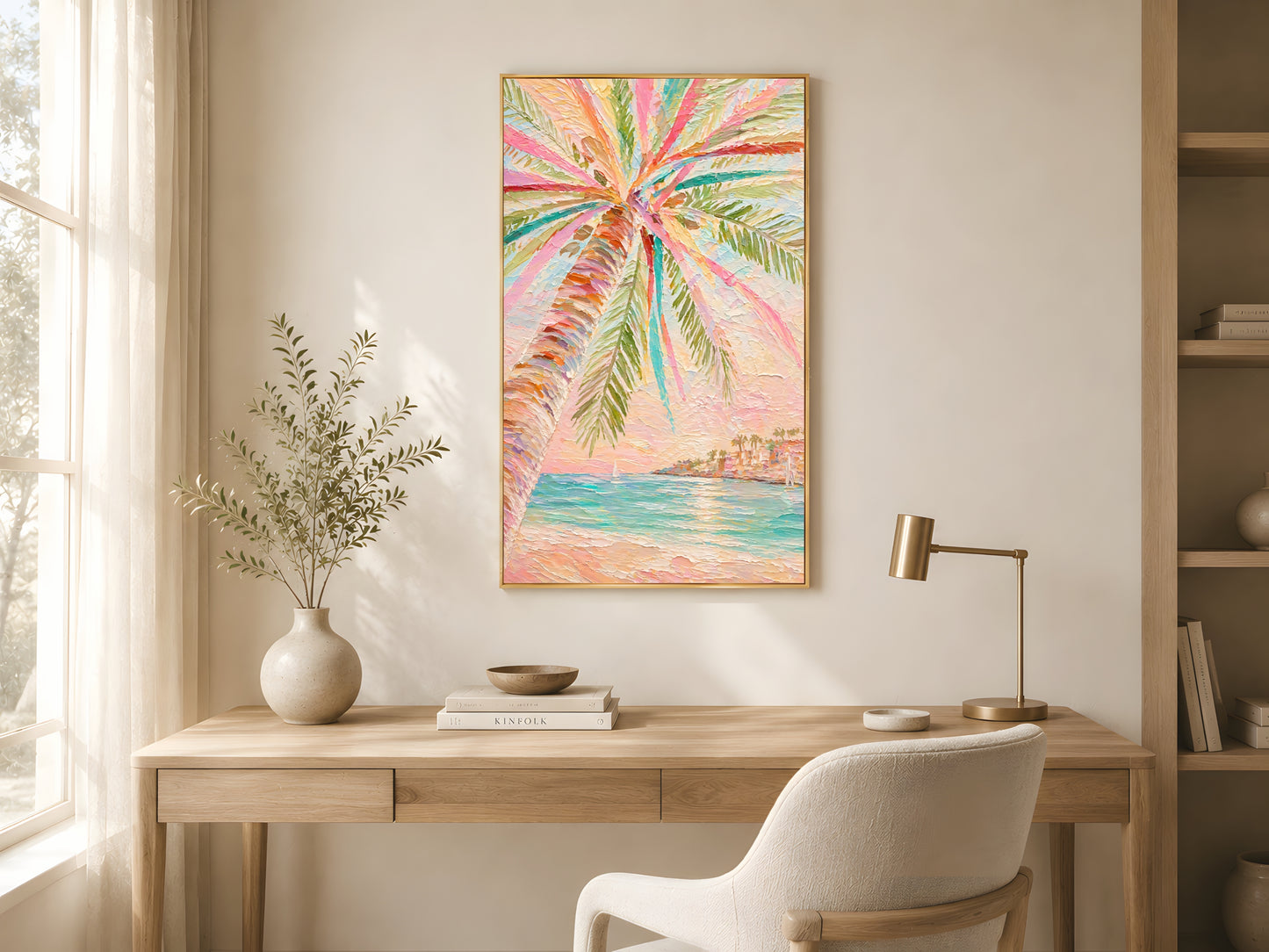Pastel palm tree impasto wall art in gold frame above wooden desk in bright minimalist home office with cream armchair and warm natural light