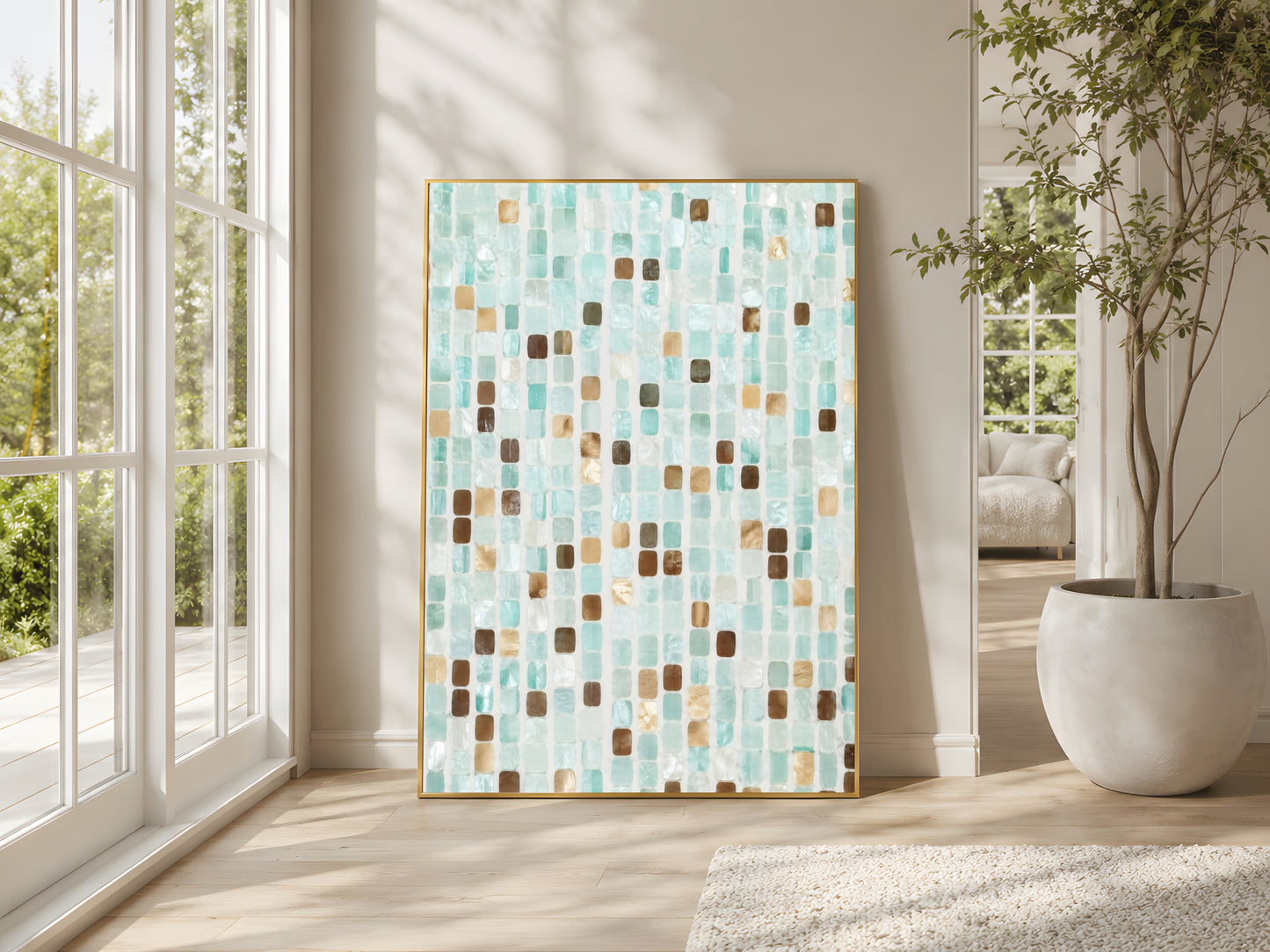 Teal mosaic tile abstract print in gold frame beside floor-to-ceiling windows in bright Mediterranean living room with large indoor plant and warm natural light
