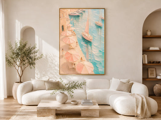 Framed Mediterranean harbor painting print in pink and teal in a warm neutral living room with white curved sofa, olive tree and coffee table