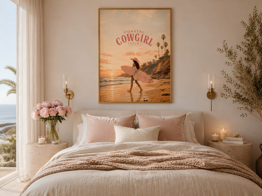 Coastal Cowgirl framed print above a bed with blush pink bedding, pink peonies, and warm candlelit bedroom atmosphere