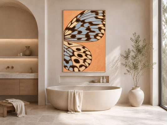 Terracotta blue butterfly wing art print framed above a freestanding tub in a warm neutral bathroom