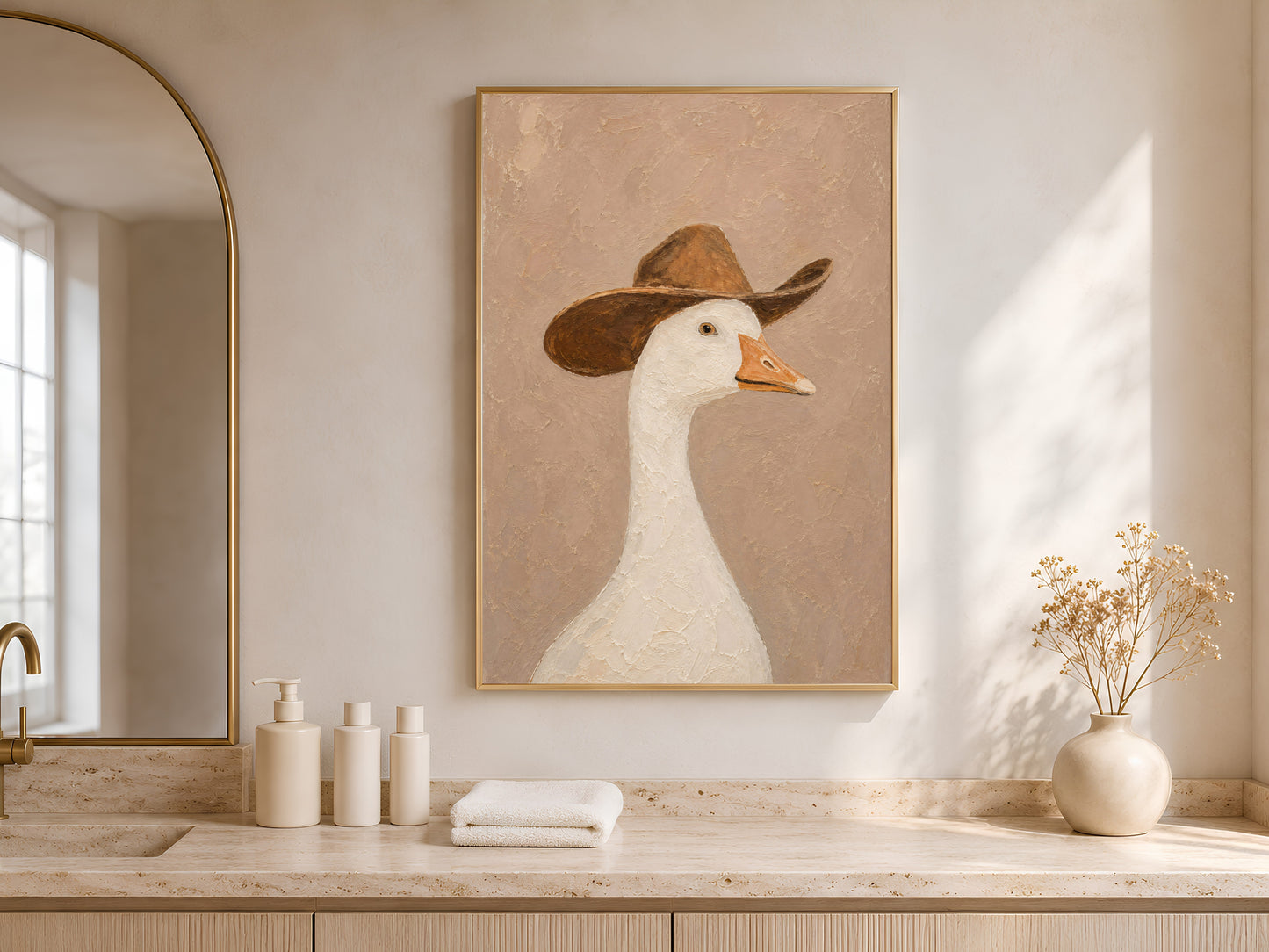 Framed cowboy goose print on a warm oak sideboard with white ceramic vessels beside an arched window with soft natural light
