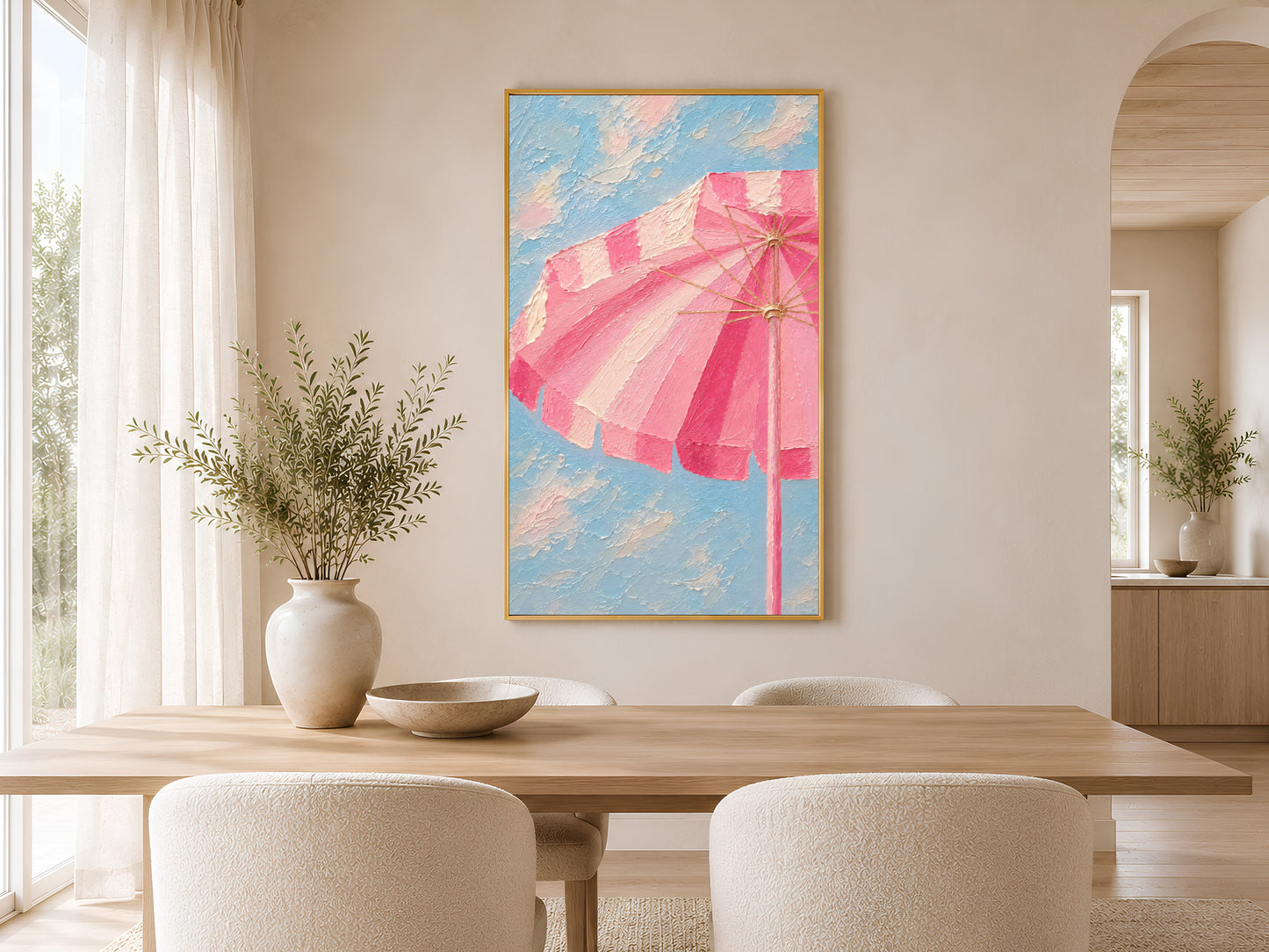 Framed pink beach umbrella wall art in a minimal warm dining room with round wooden table, chairs and ceramic vases
