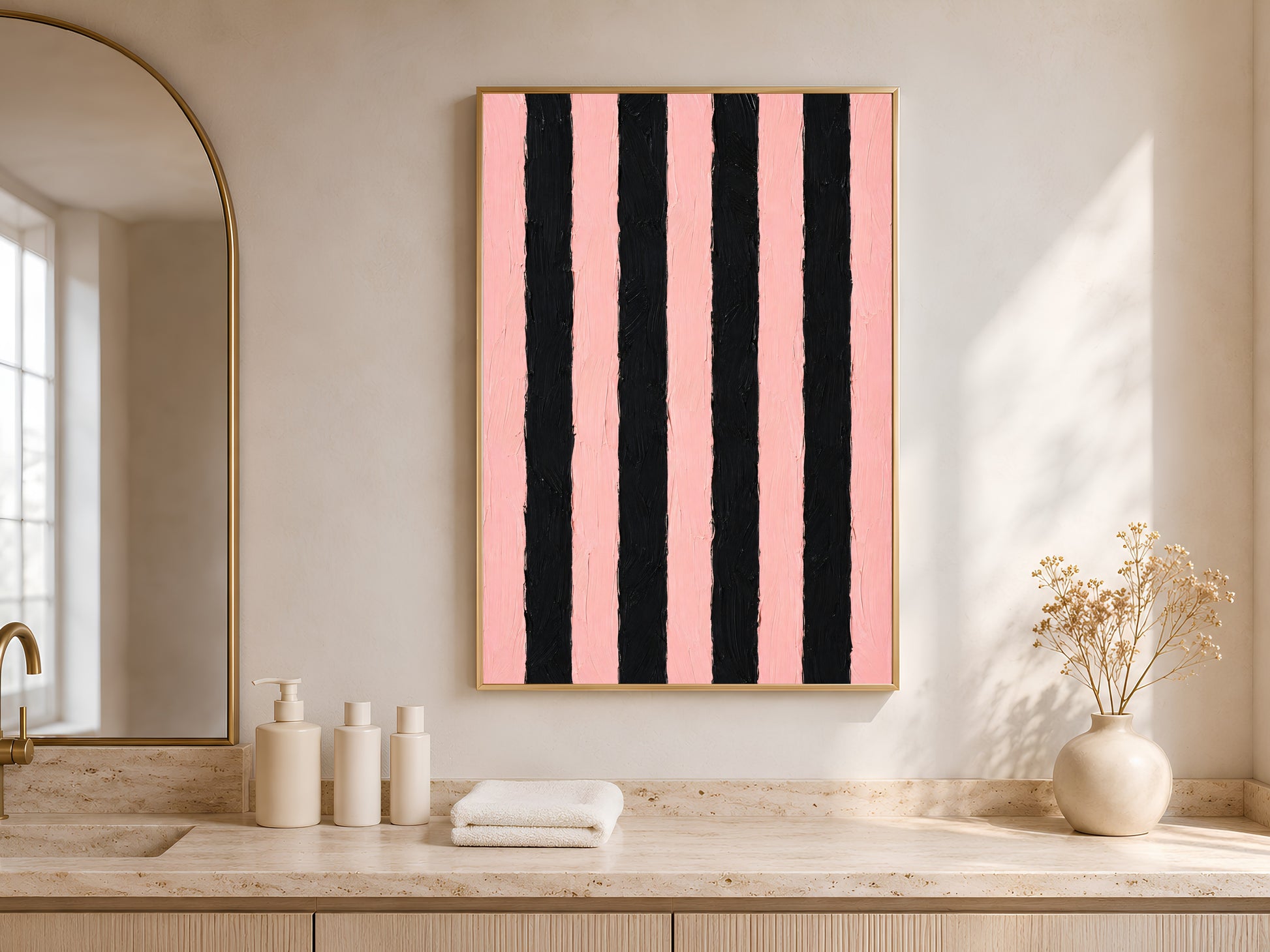 Bold pink and black stripe print in gold frame in bright entryway with arched niche white vases and soft shadows
