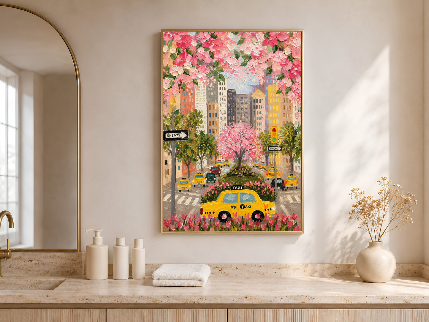 NYC taxi cherry blossom wall art in gold frame on travertine console table in bright entryway with arched mirror

