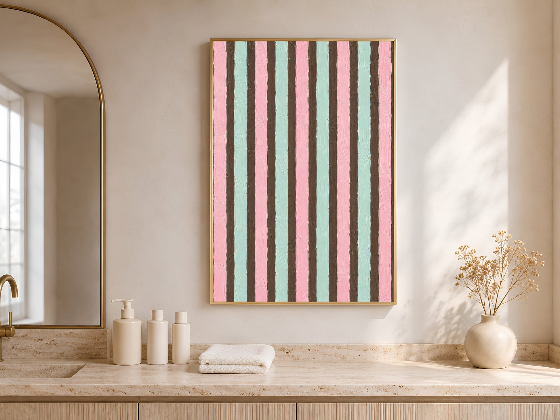 Pink mint stripe wall art in gold frame in bright neutral bathroom with arched niche and white towels
