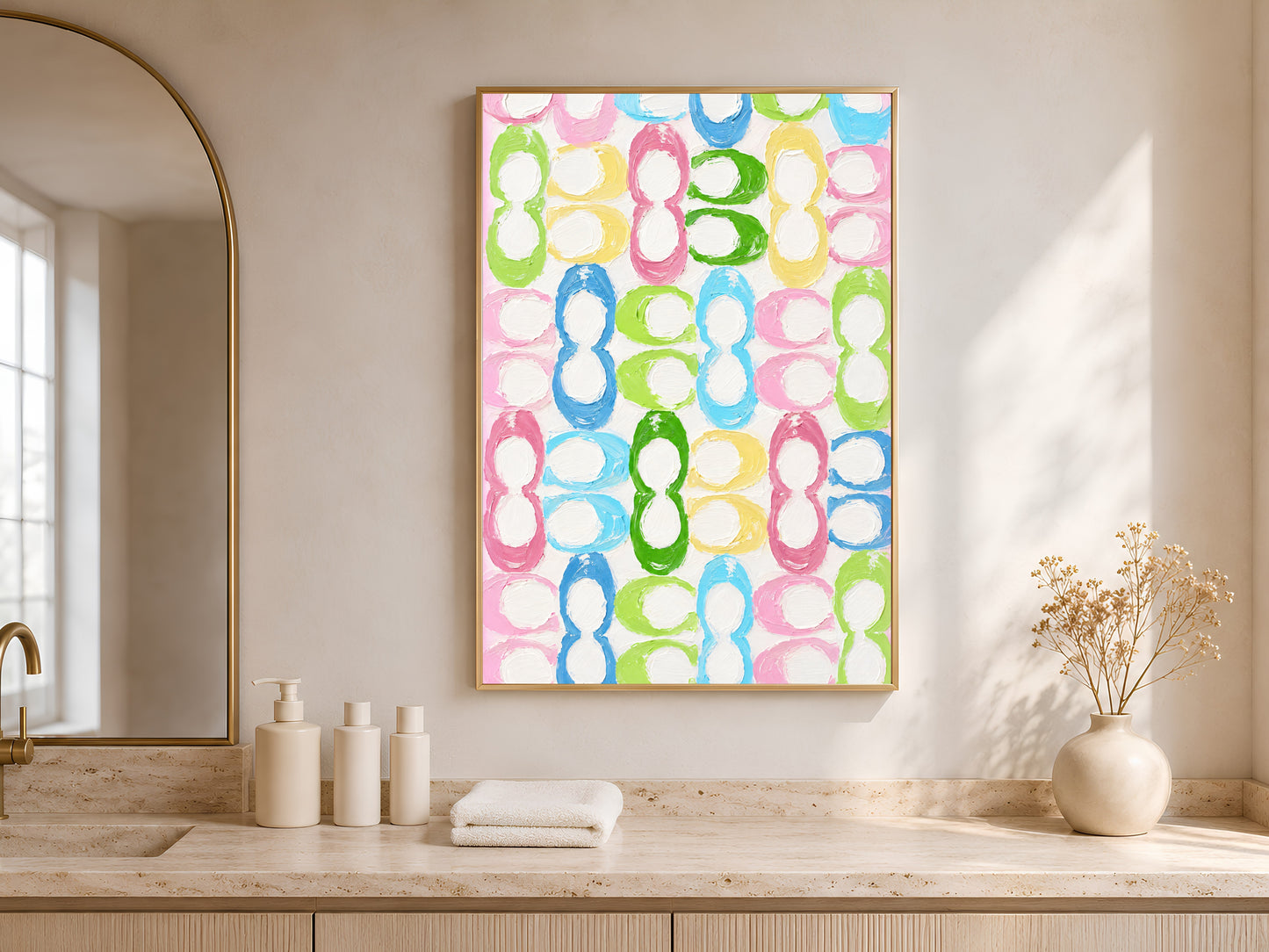 Colorful retro loop pattern print in gold frame in bright entryway with arched mirror and white ceramic vases
