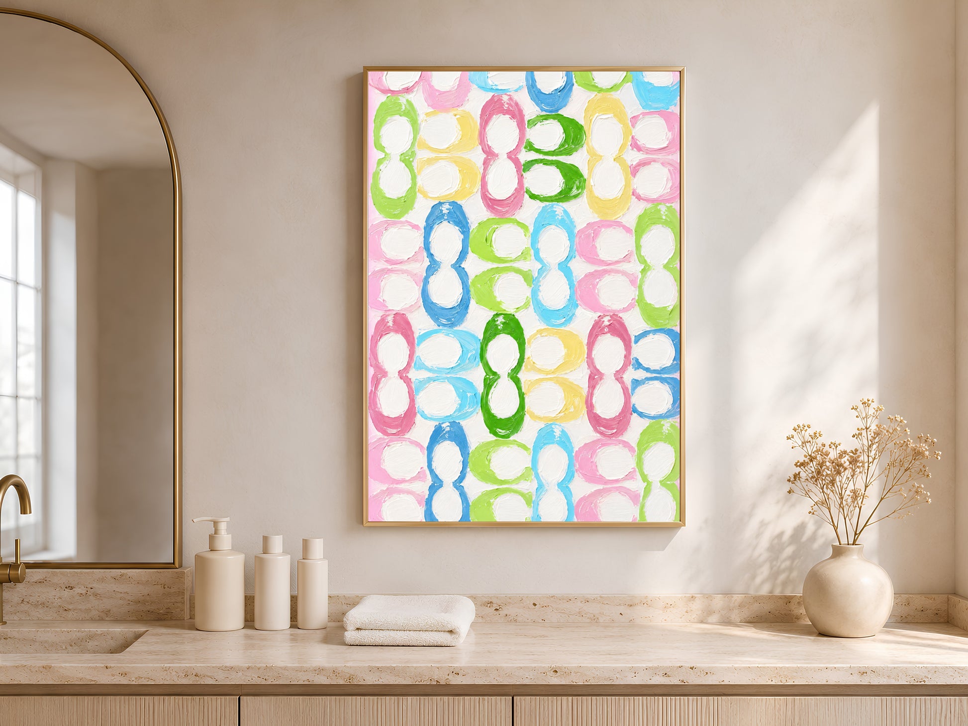 Colorful retro loop pattern print in gold frame in bright entryway with arched mirror and white ceramic vases
