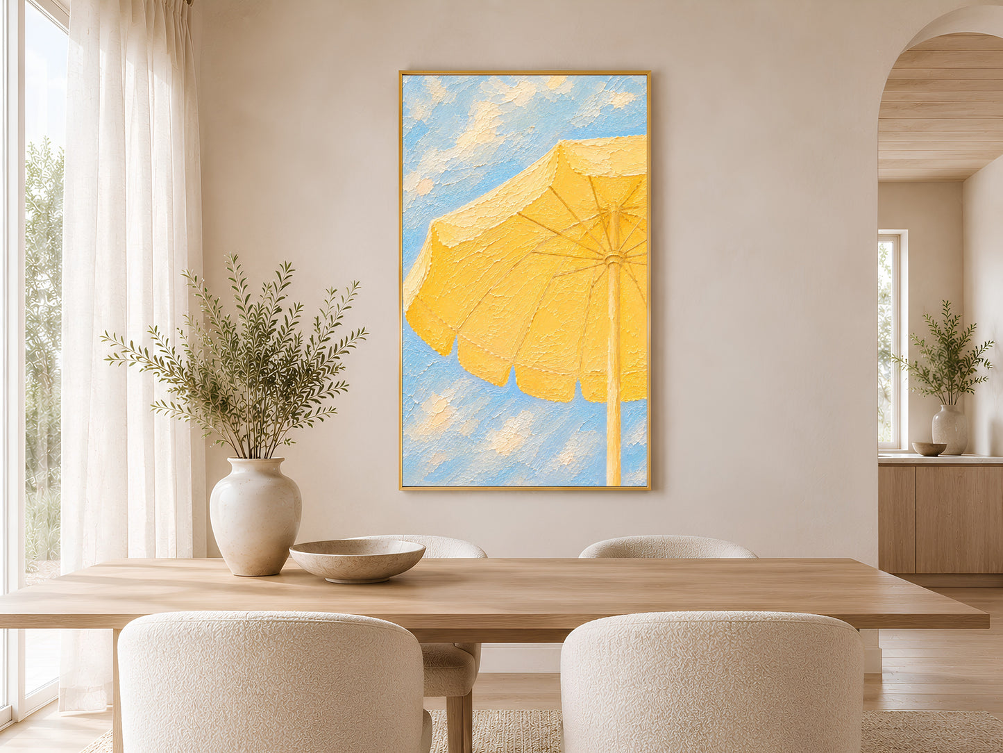 Framed yellow beach umbrella impasto print in a warm minimal dining room with round wooden table, chairs and ceramic vases
