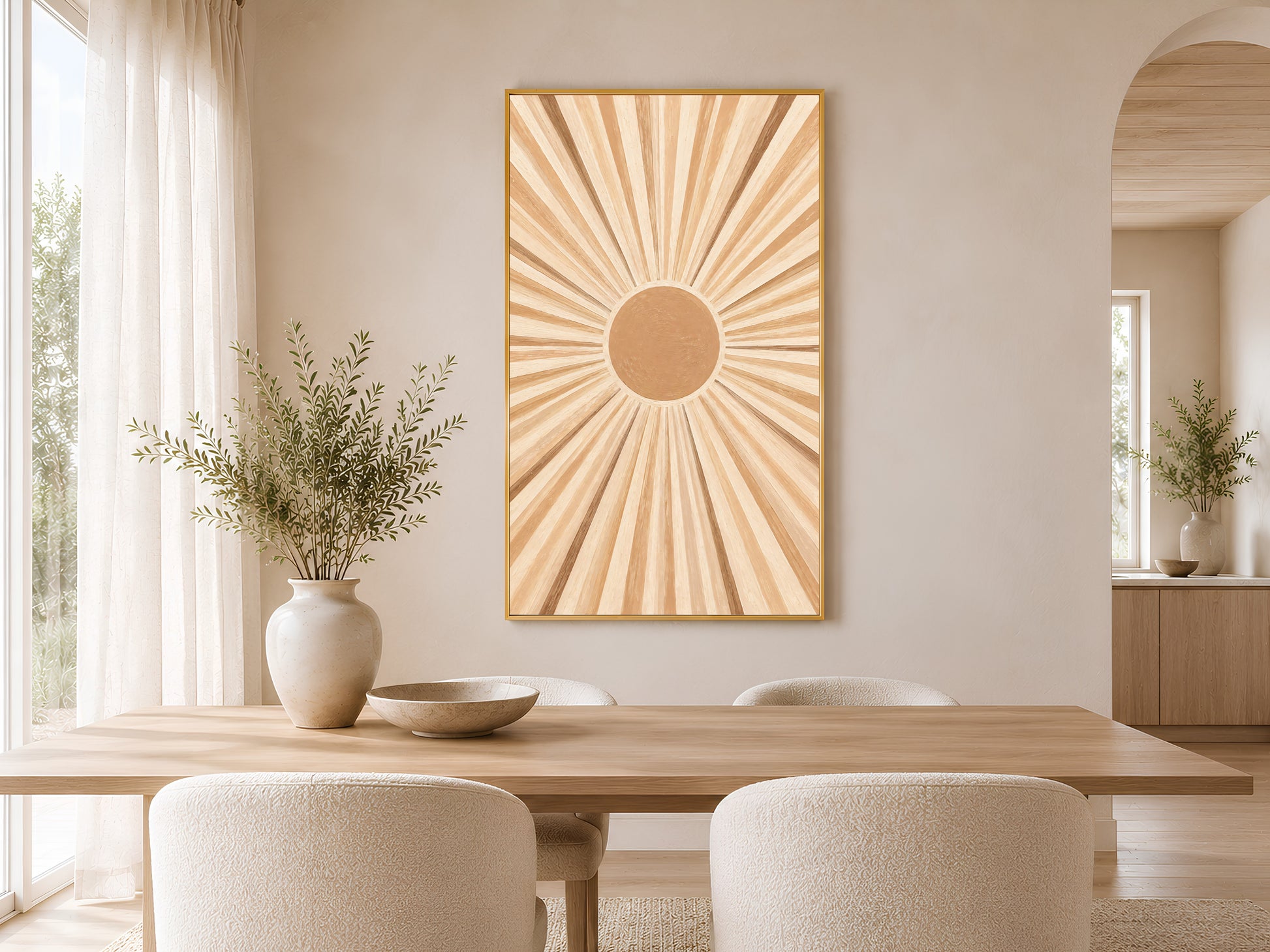 Framed impasto sunburst print on warm white wall in minimal dining room with wooden table and neutral chairs
