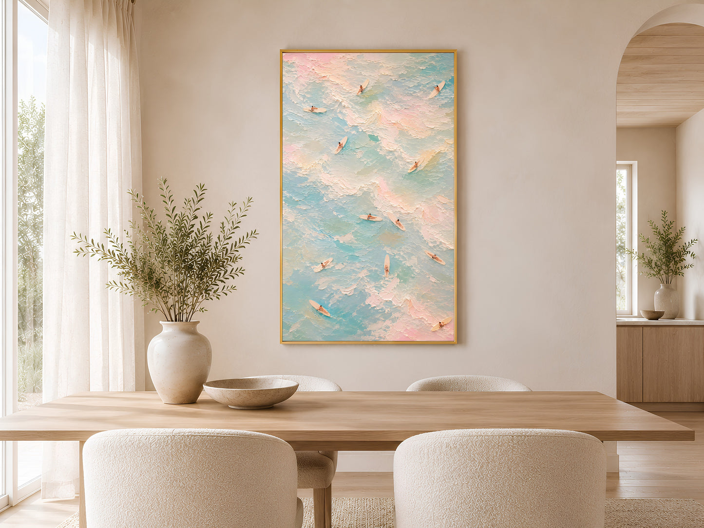 Pastel surfer wall art in gold frame above a round dining table in a warm neutral Scandinavian dining room