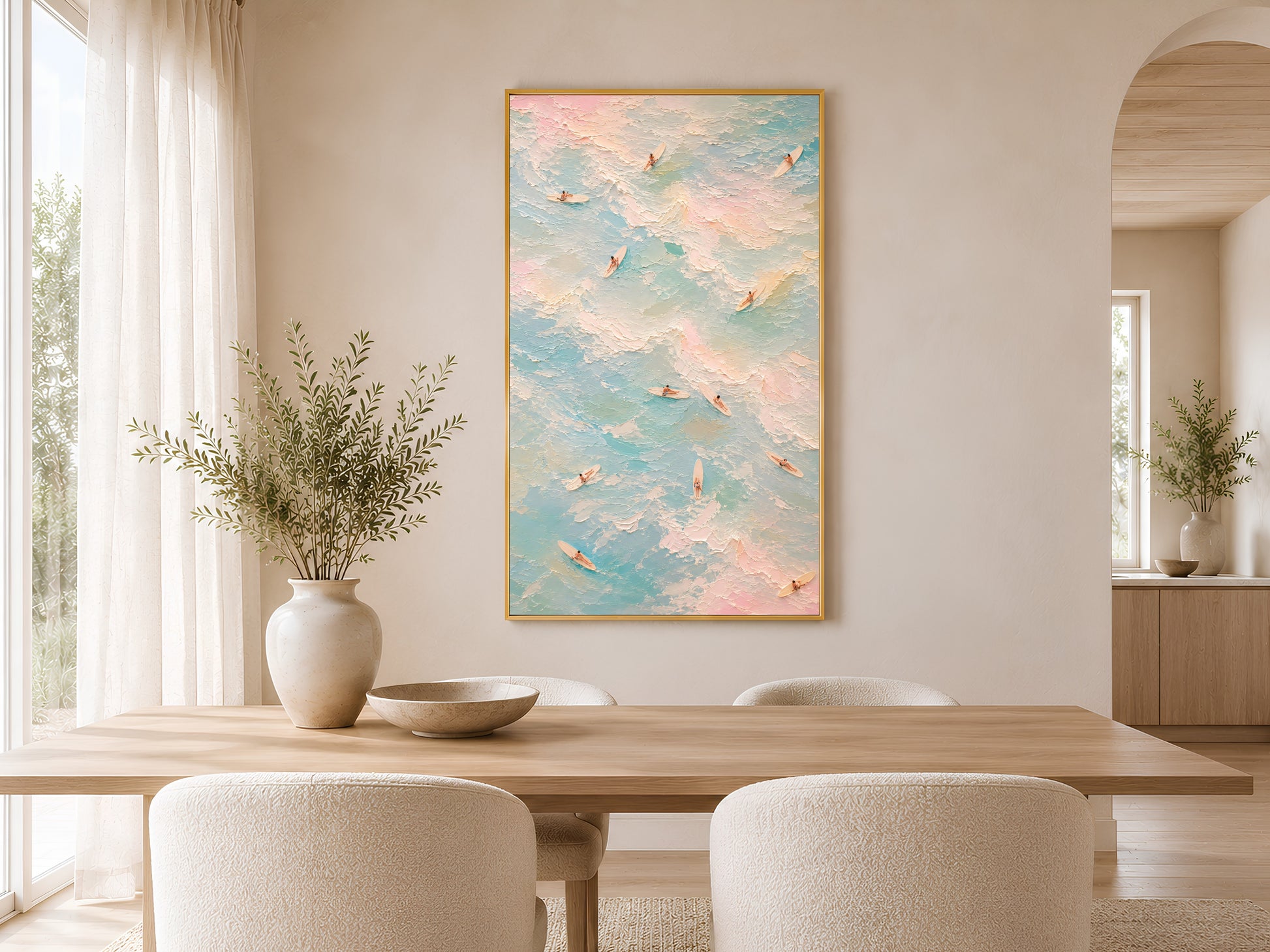 Pastel surfer wall art in gold frame above a round dining table in a warm neutral Scandinavian dining room