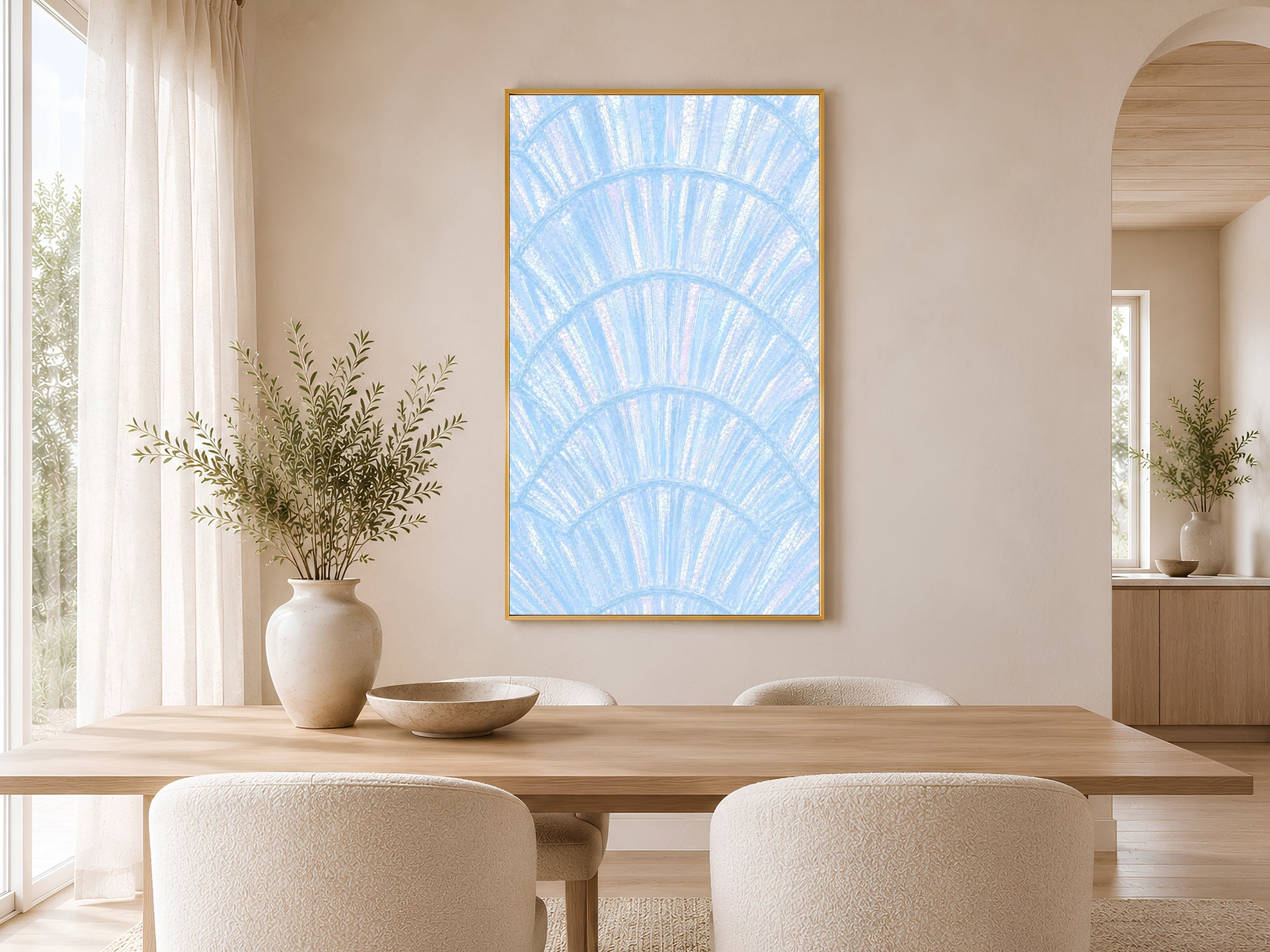 Blue capiz shell coastal print in gold frame above a round dining table in a warm neutral Scandinavian dining room