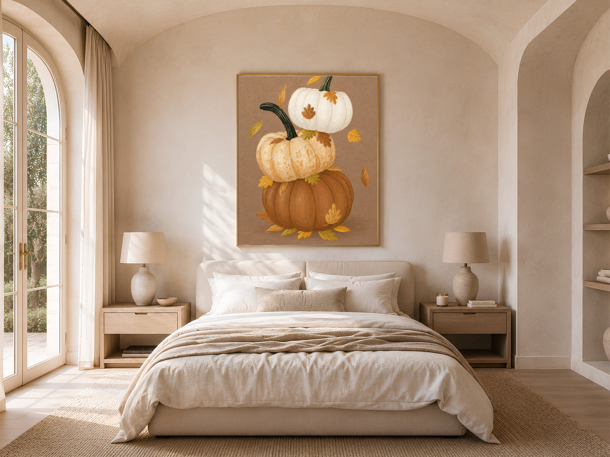 Framed stacked pumpkin print with autumn leaves above a neutral bedroom bed