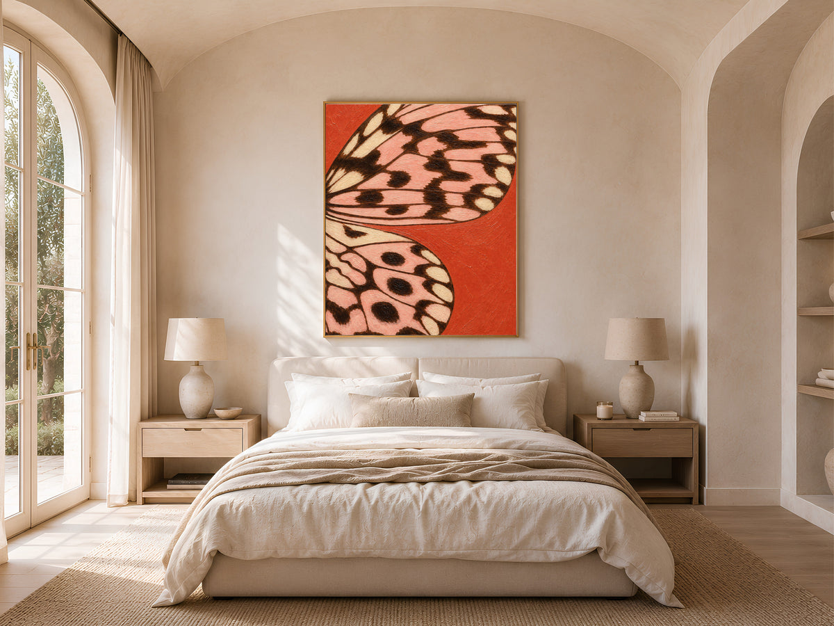 Tomato red butterfly wing art print framed above a bed in a bright, sunlit bedroom