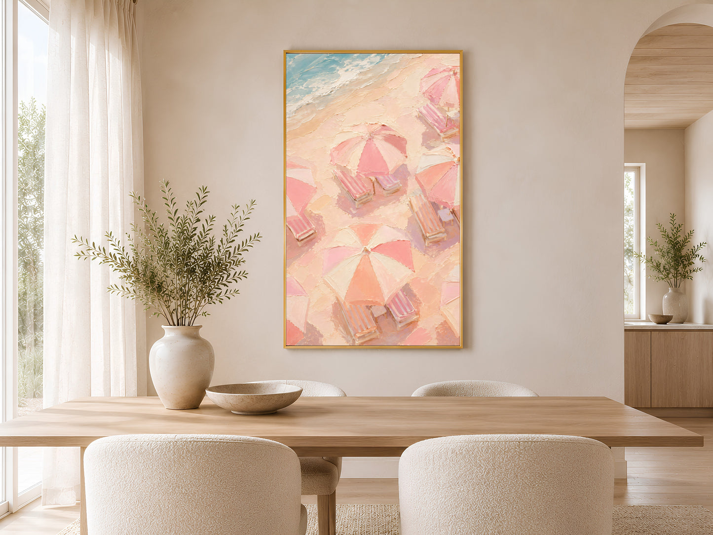 Pastel beach umbrella coastal print in gold frame styled in a bright neutral dining room with round table and linen chairs