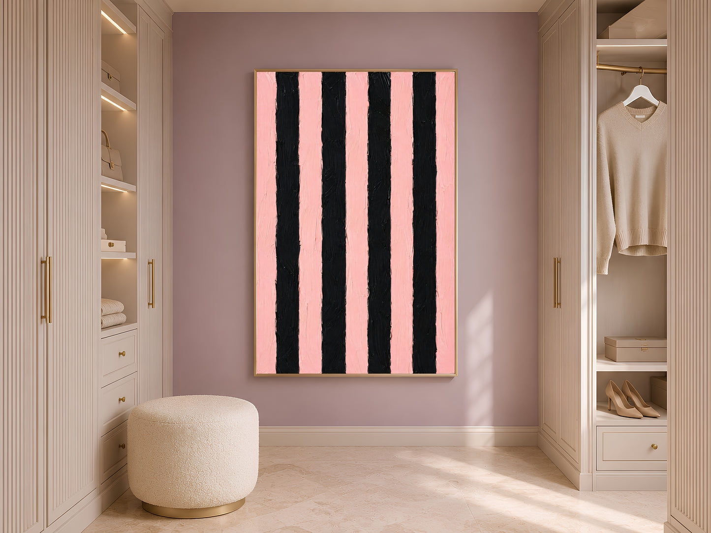 Bold pink and black stripe print in gold frame in styled dressing room with wardrobe and cream ottoman
