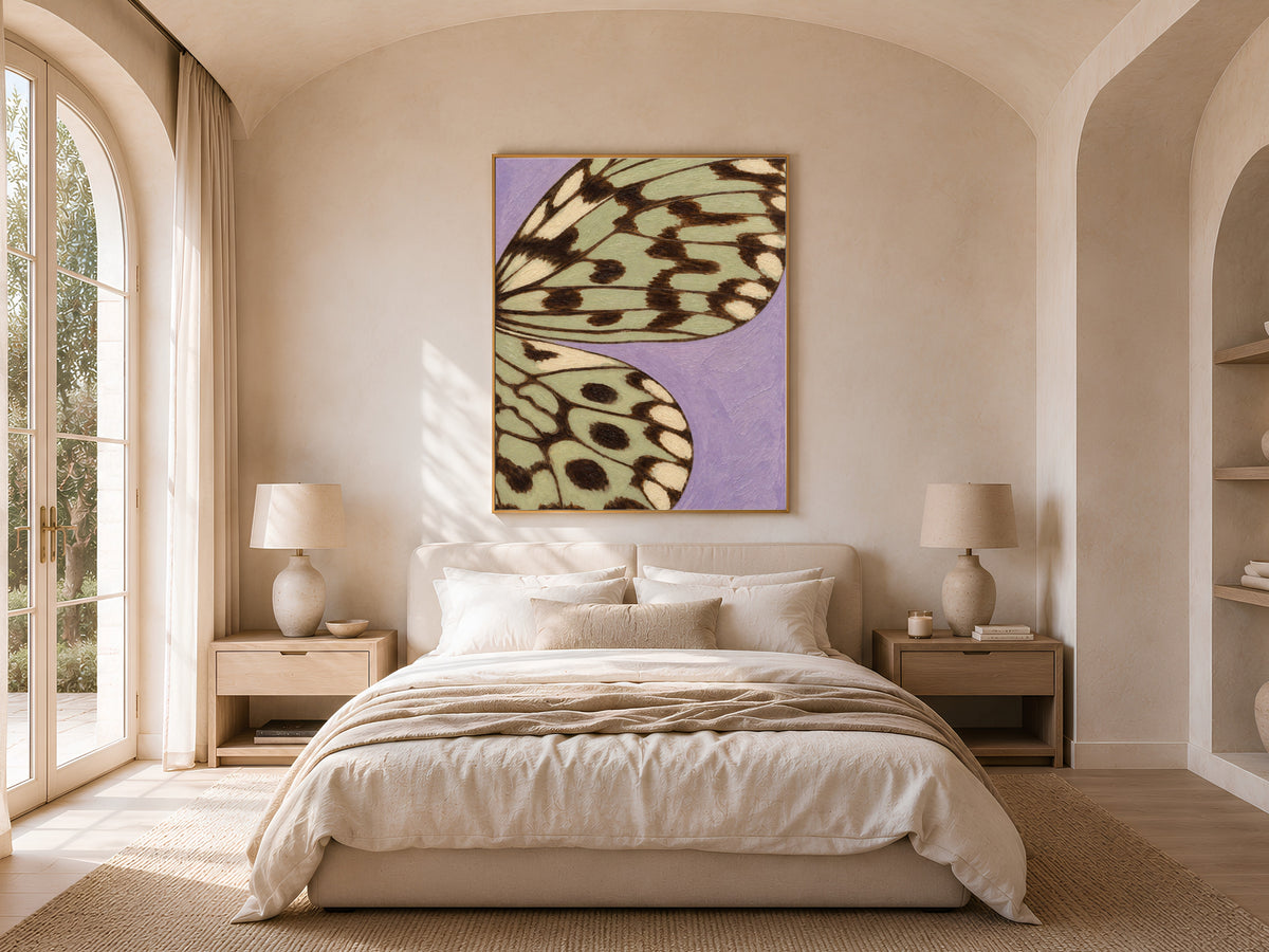 Lavender and sage green butterfly wing print framed above a bed in a bright, sunlit bedroom