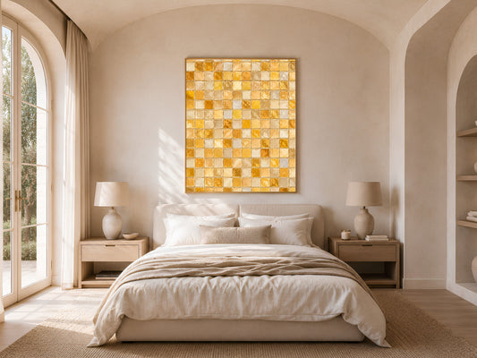 Gold mosaic wall art framed above a bed in a warm neutral bedroom with arched window and natural light
