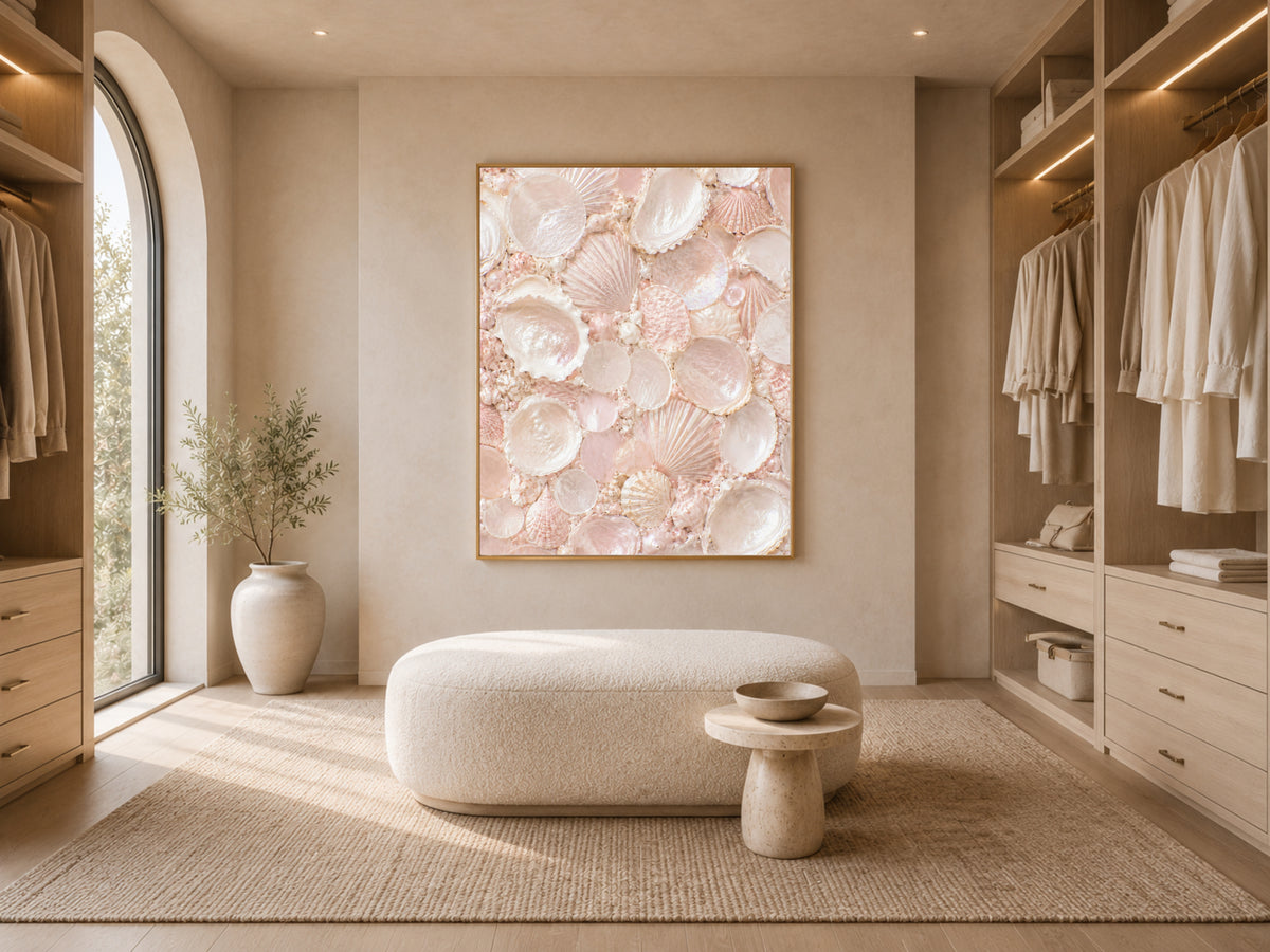 Framed blush pink shell mosaic print displayed in a bright walk-in closet with an ottoman