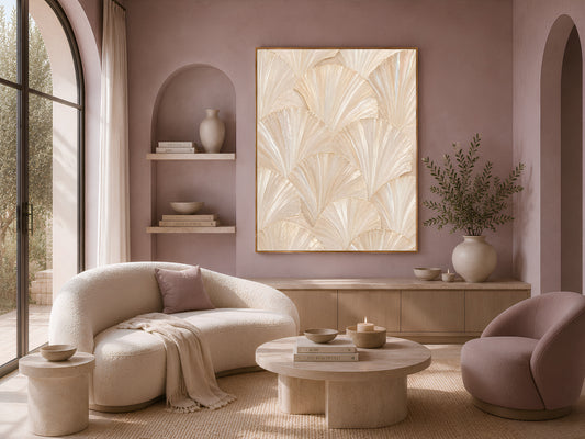 Framed capiz shell wall art above a curved cream sofa in a neutral living room with a round wood coffee table and built-in shelving.
