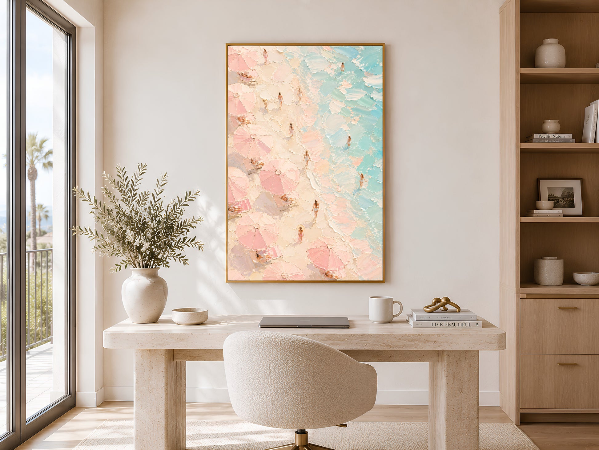 Framed aerial beach impasto print in a bright home office with wooden desk, open shelving and warm natural light
