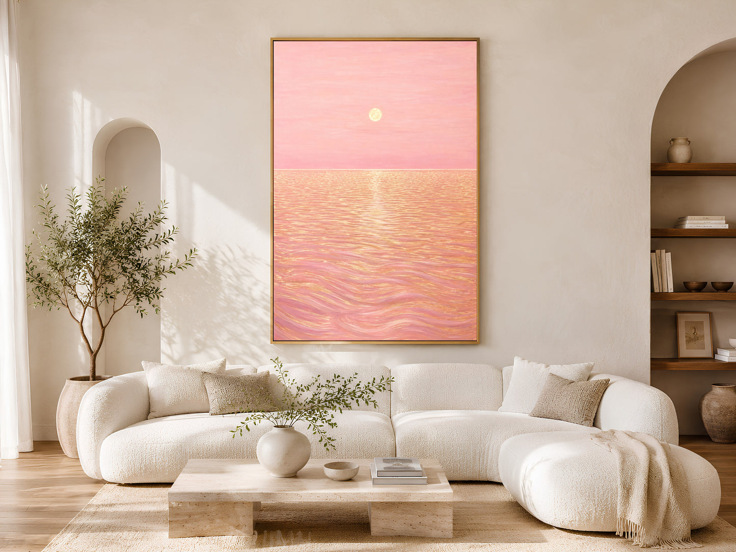 Pink sunset ocean canvas print framed in gold above a cream boucle sofa in living room

