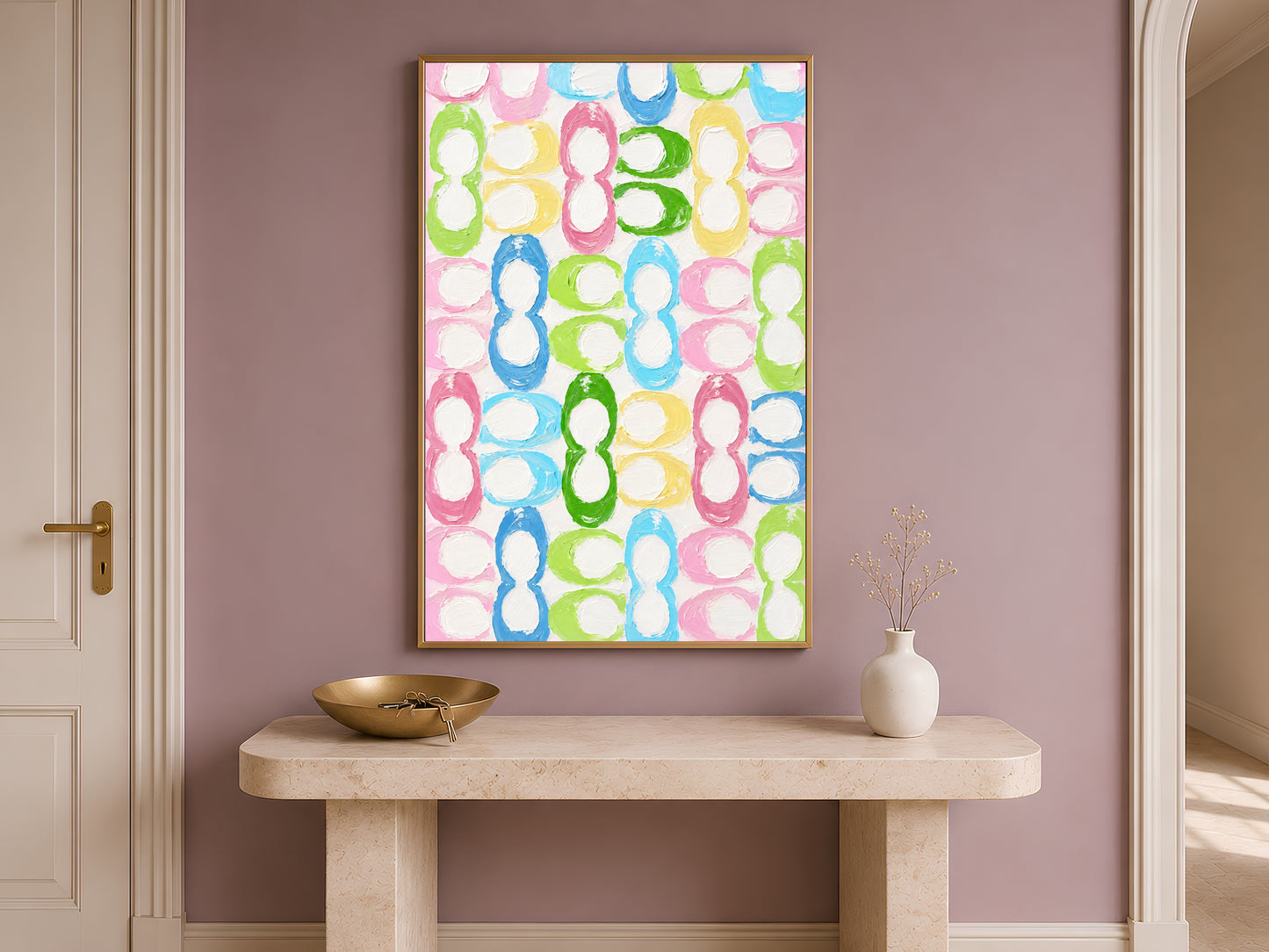 Colorful retro loop pattern wall art in gold frame on travertine console table in hallway with neutral vase
