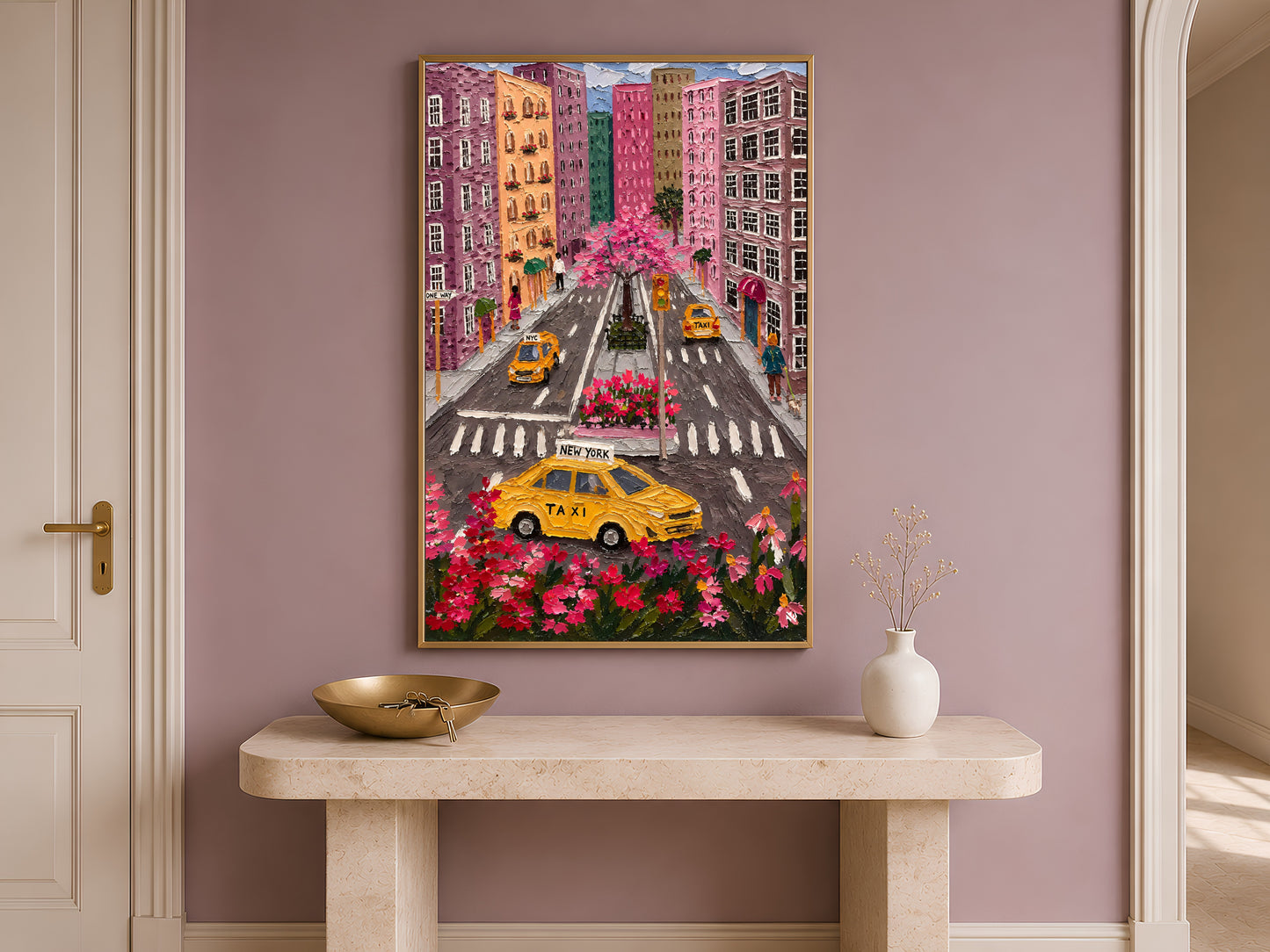 Colorful NYC taxi aerial wall art in gold frame on travertine console table in hallway with mauve accent wall
