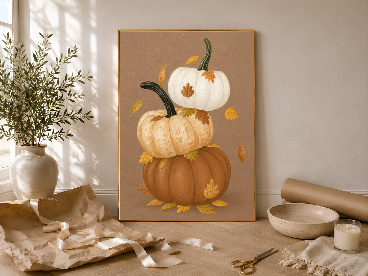 Stacked pumpkin wall art with autumn leaves styled with linen and dried florals