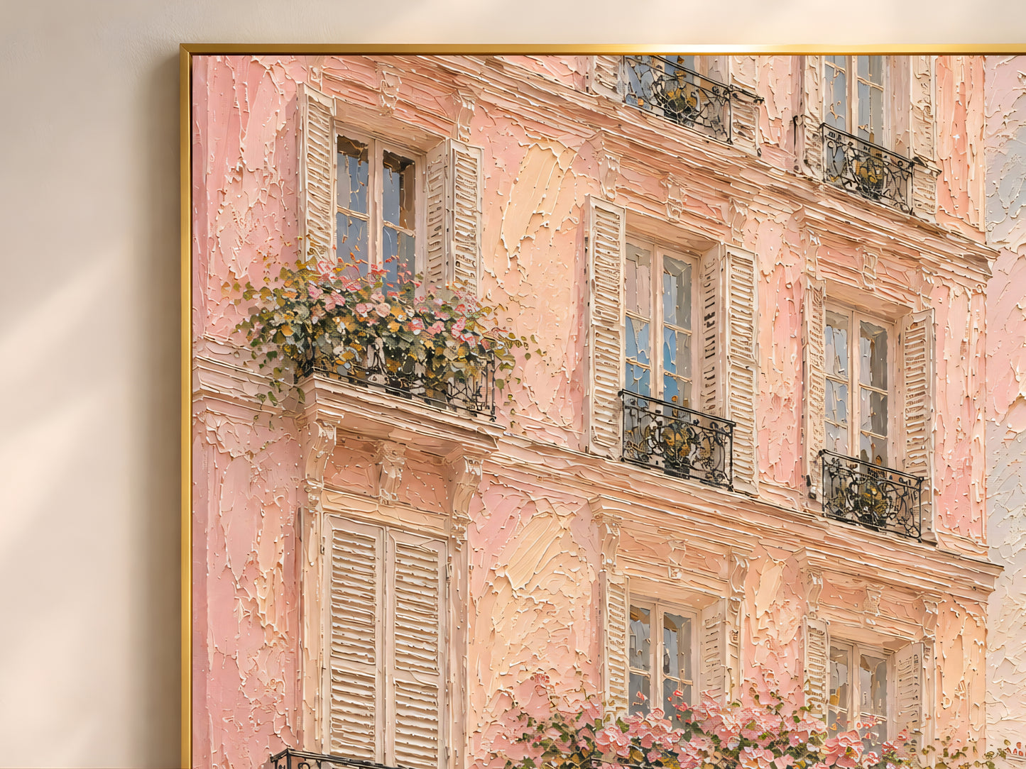 Close-up of pink Paris building impasto art print in a gold frame showing thick painterly texture with blush façade, ornate balconies, shutters and climbing roses
