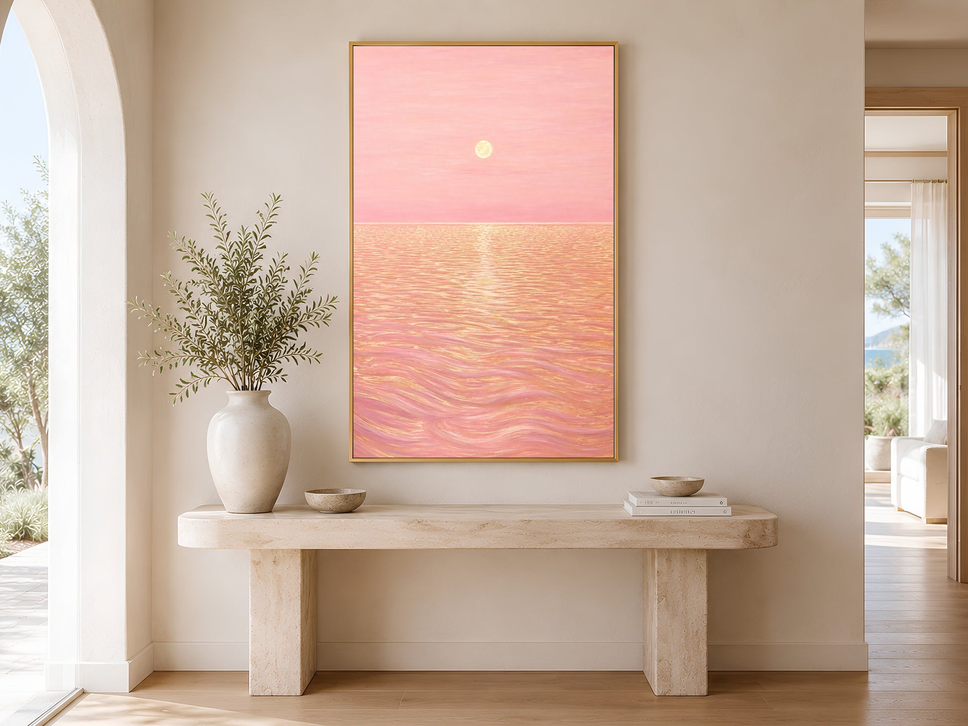 Pink sunset ocean print framed in gold hanging above a wooden entryway bench with plant
