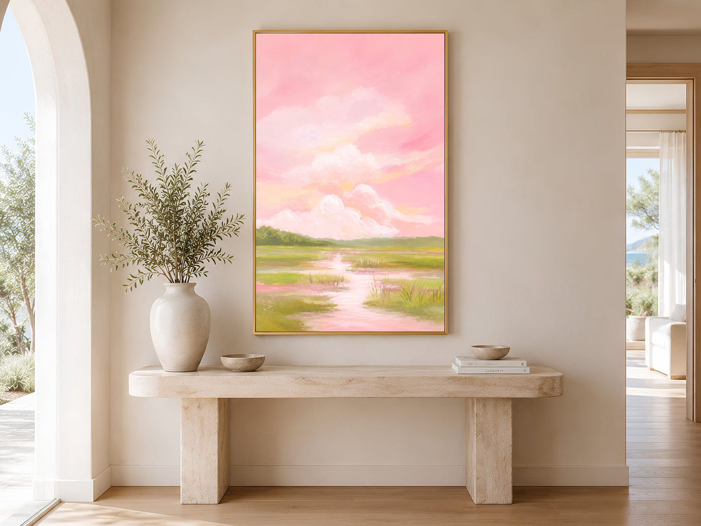Pink sky marsh landscape wall art above console table in sunlit hallway
