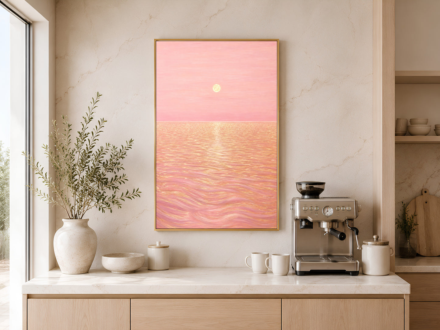 Pink sunset ocean print displayed on kitchen counter beside espresso machine and ceramic vase
