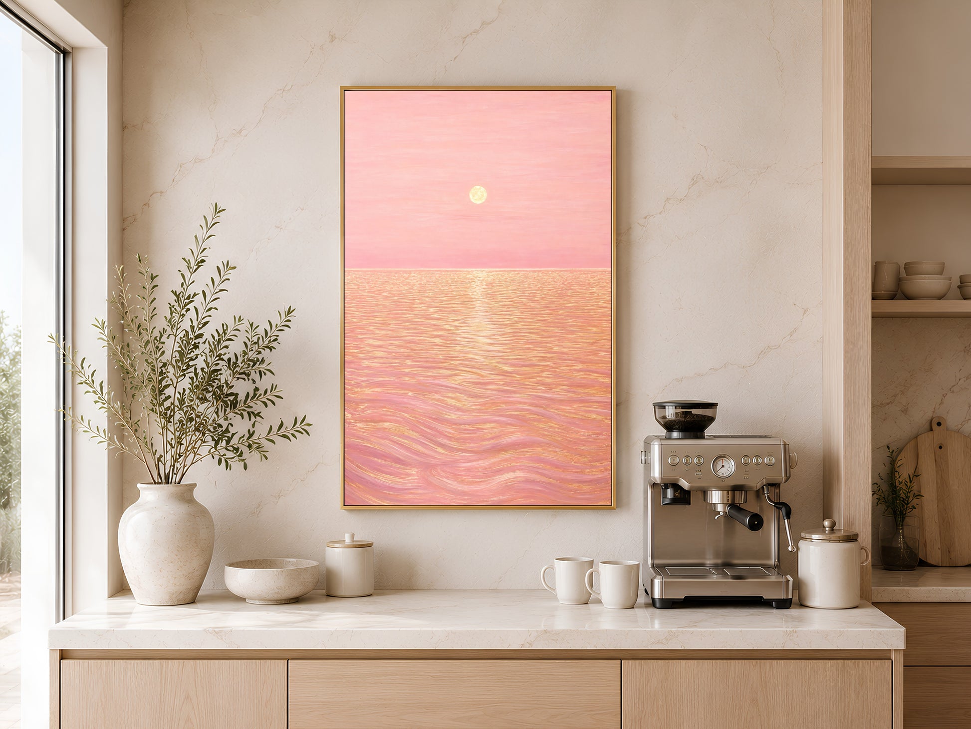 Pink sunset ocean print displayed on kitchen counter beside espresso machine and ceramic vase
