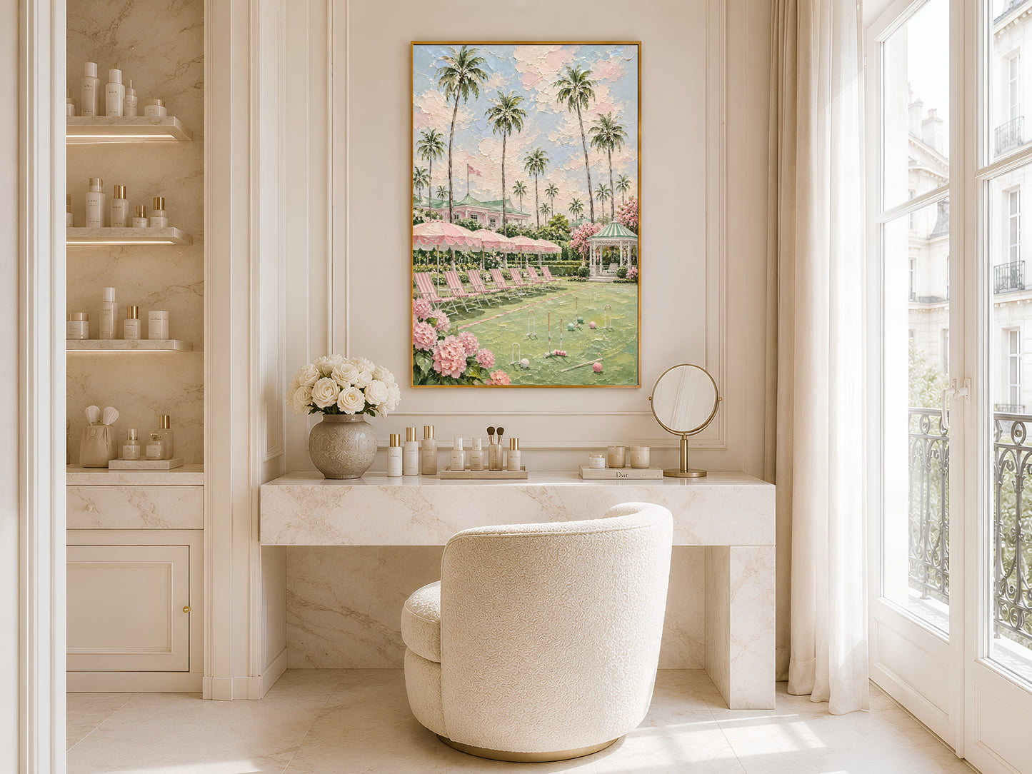 Gold-framed pink croquet lawn and palm tree impasto print in a bright bathroom beside a freestanding white bathtub with large windows and open shelving with flowers
