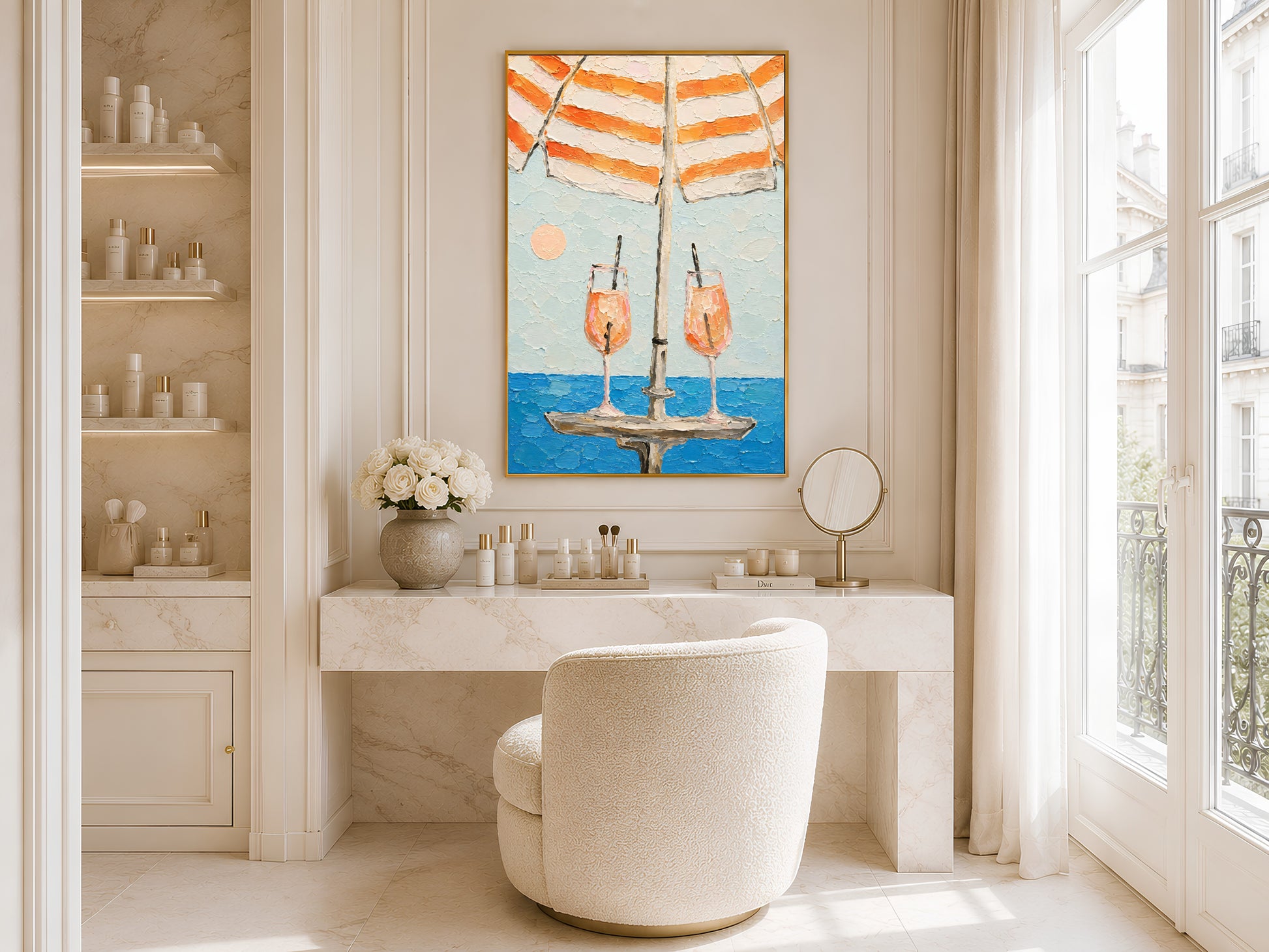 Framed aperol spritz beach umbrella print displayed in a bright white bathroom with round mirror, vanity shelving, and freestanding soaking tub

