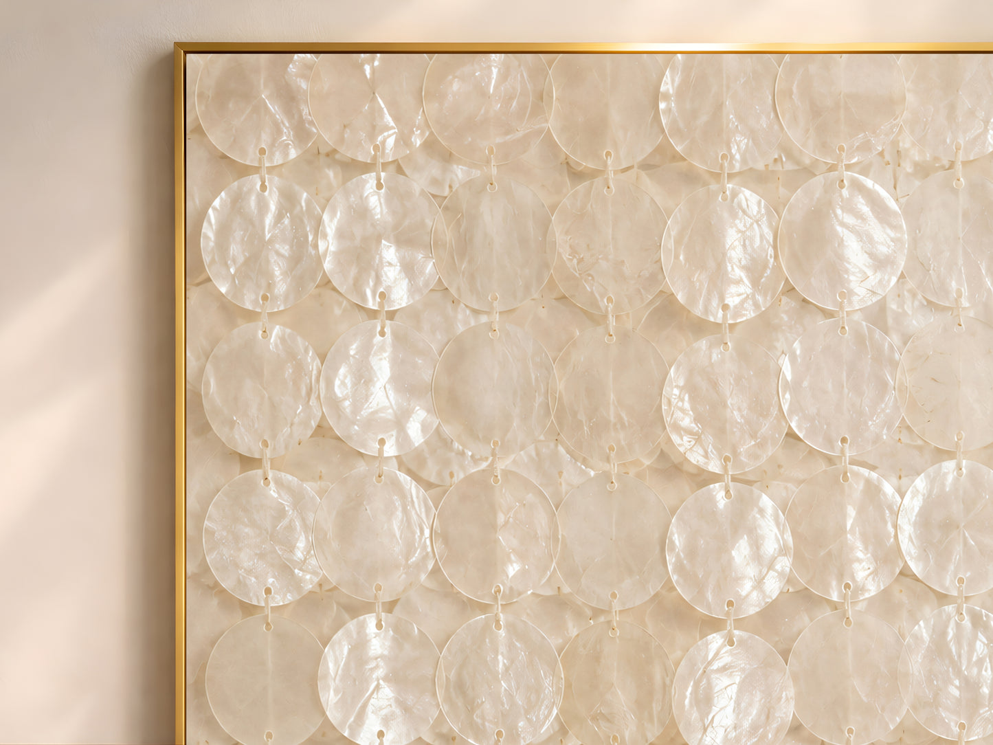 Close-up of the capiz shell wall art print showing the full pattern of translucent ivory and cream shell discs strung in vertical rows with subtle iridescent shimmer and warm pearlescent texture
