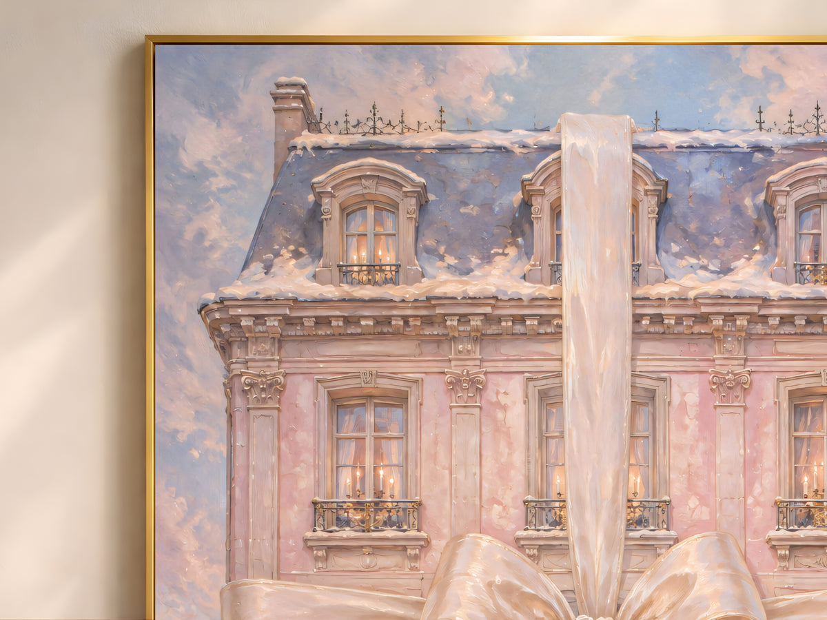 Close-up of pink chateau Christmas art showing satin bow, snowy rooftop, and candlelit windows