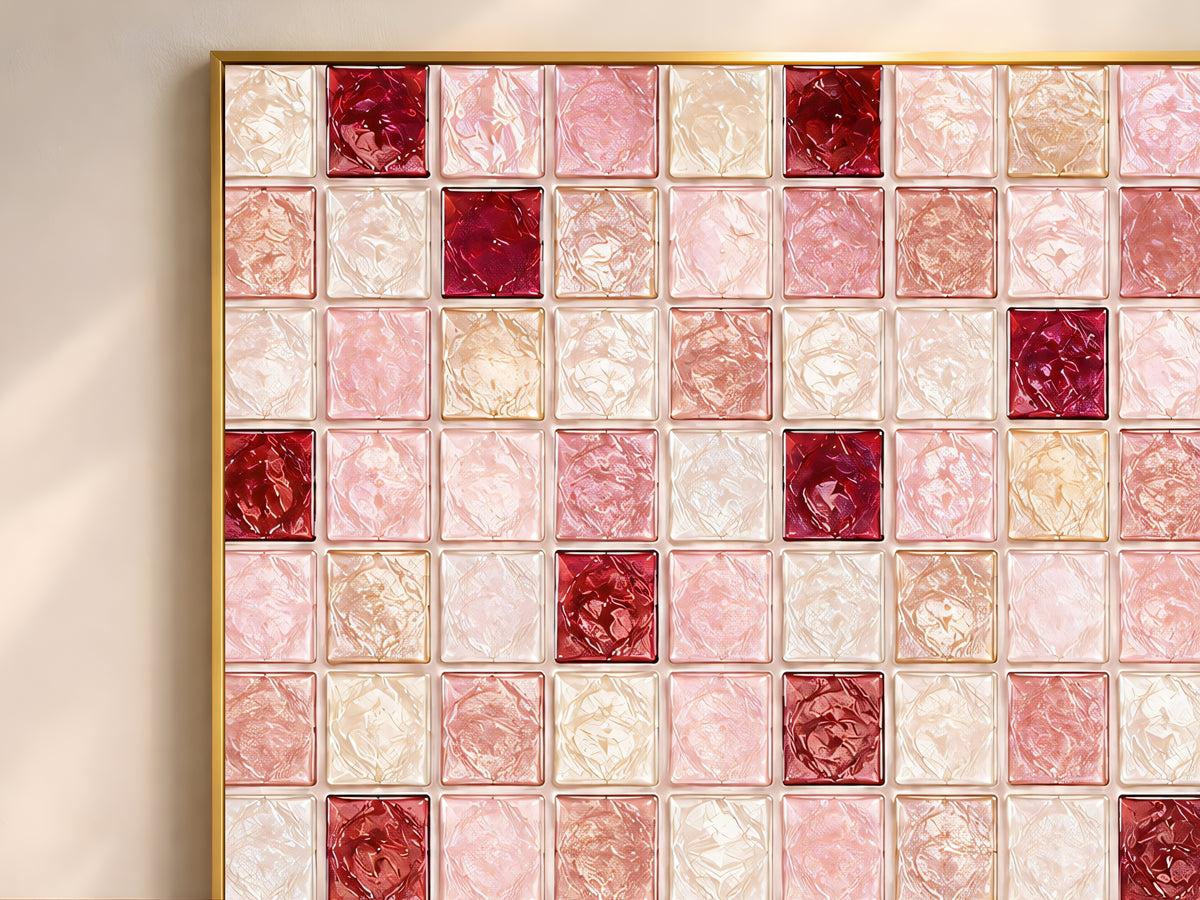 Close-up of geometric mosaic wall art in blush, rose, burgundy, and cream glass-tile pattern