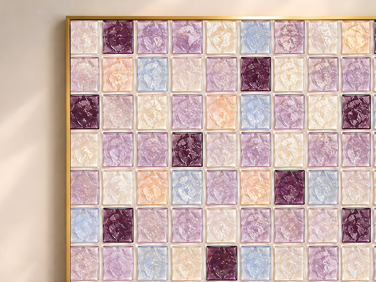 Close-up of geometric mosaic wall art in plum, lavender, powder blue, and peach glass-tile pattern