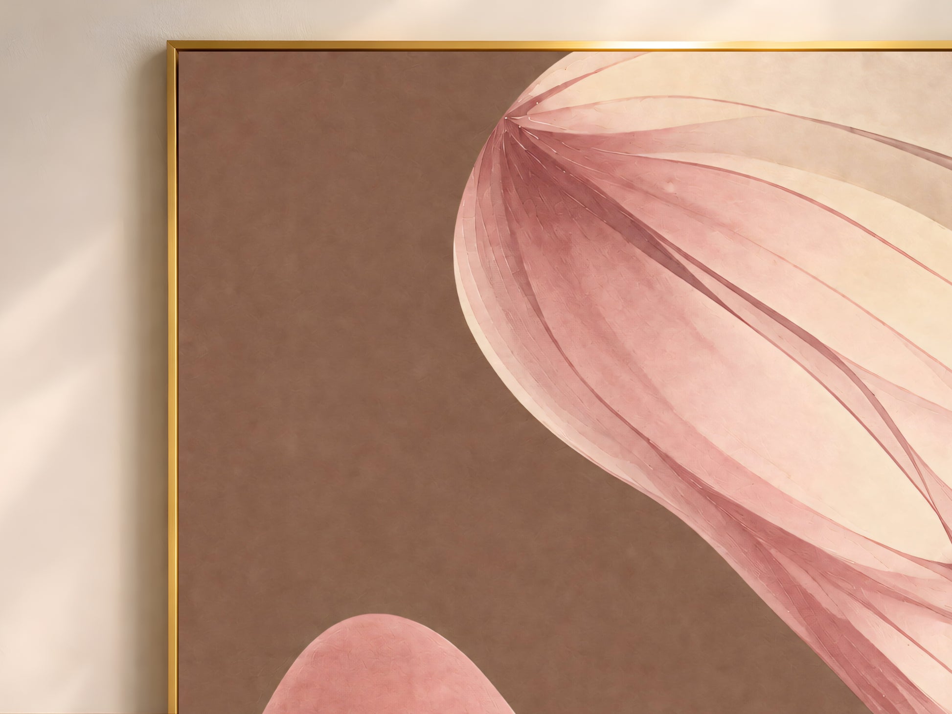 Close-up of mocha abstract ribbon print in a thin gold frame on a warm brown wall
