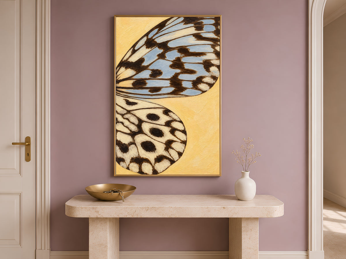 Butter yellow butterfly wing print framed on a mauve wall above a console table in an entryway